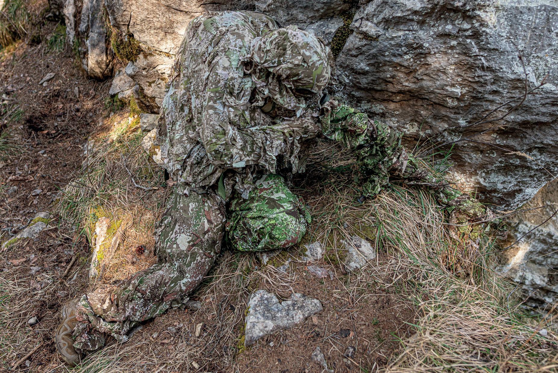 Un soldat camouflé avec un Ghost-Hoodie en CONCAMO beige/brun et vert pendant un exercice.