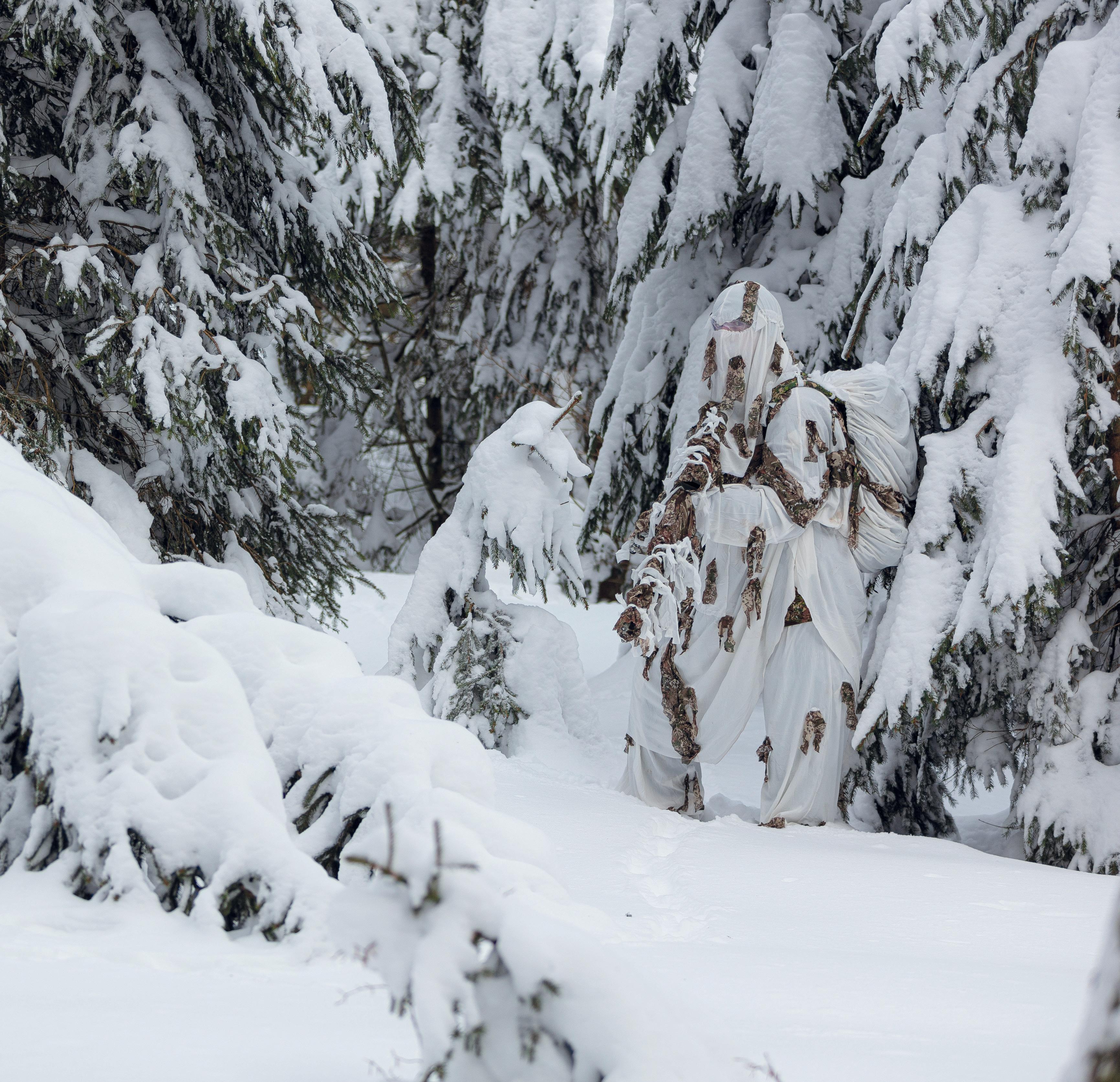 Les systèmes de camouflage GHOSTHOOD sont disponibles en plusieurs couleurs. Sur l’image (à droite), un soldat en camouflage d’hiver.