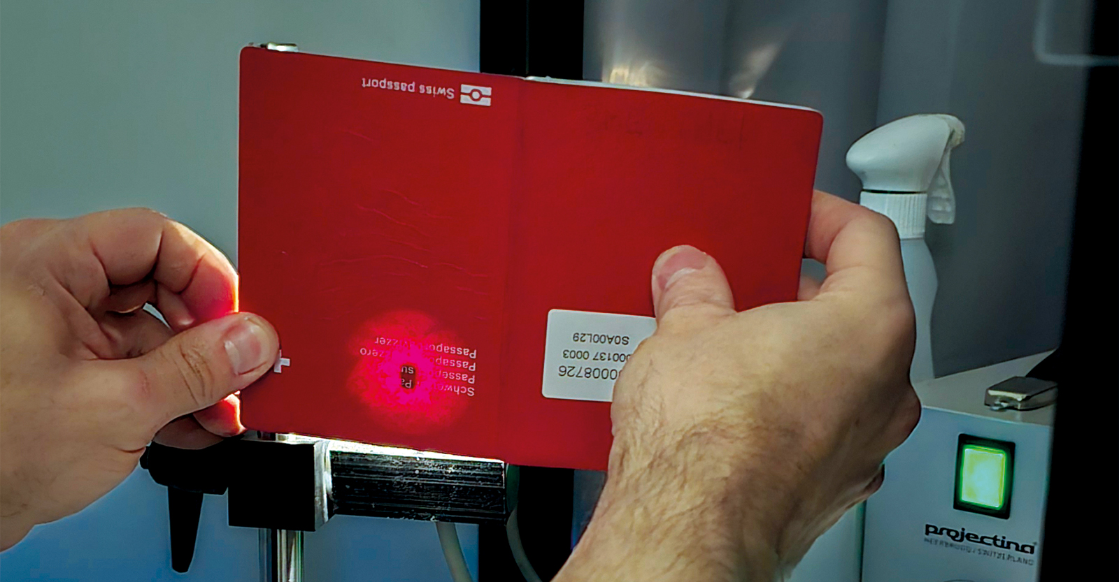L’examen à la lumière à l’aide d’une lampe puissante révèle où se trouve la puce biométrique dans ce « spécimen » de passeport suisse.