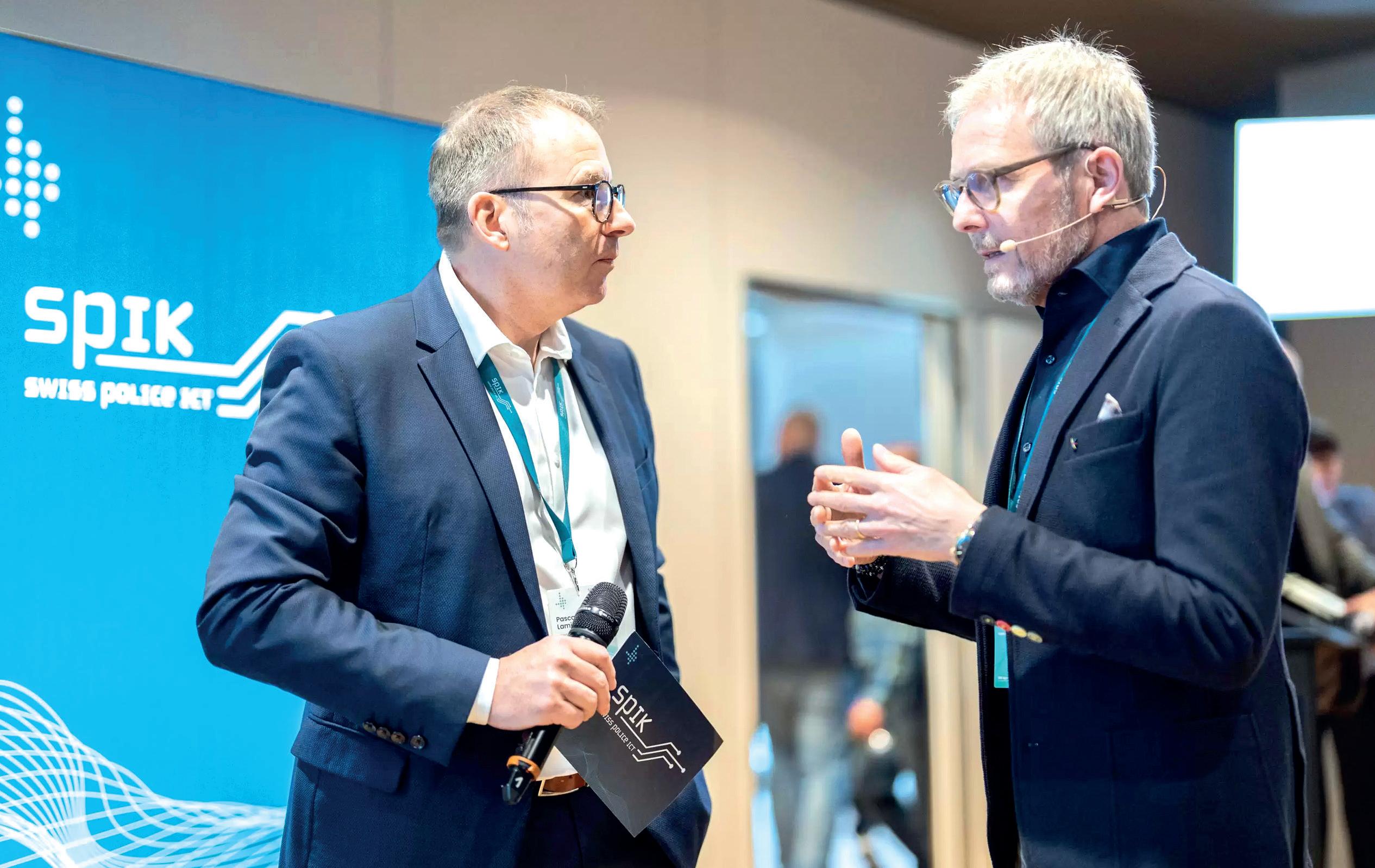 Lors du SPIK 2025, Christof Bühler, de la société SCS AG (à droite sur la photo), a présenté le prototype d’une application pour smartphone développée pour le compte d’Orell Füssli Security Printing, capable de détecter les faux billets de 20 et 50 euros.