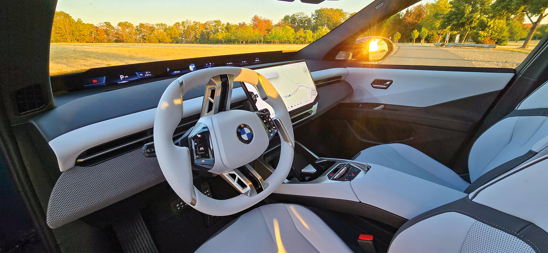 L’habitacle de l’iX3 avec écran central au « Freecut Design » et  « Panoramic Vision » dans la partie inférieure du pare-brise. À cela s’ajoutent le volant multifonction et, en option, un affichage tête haute en 3D.